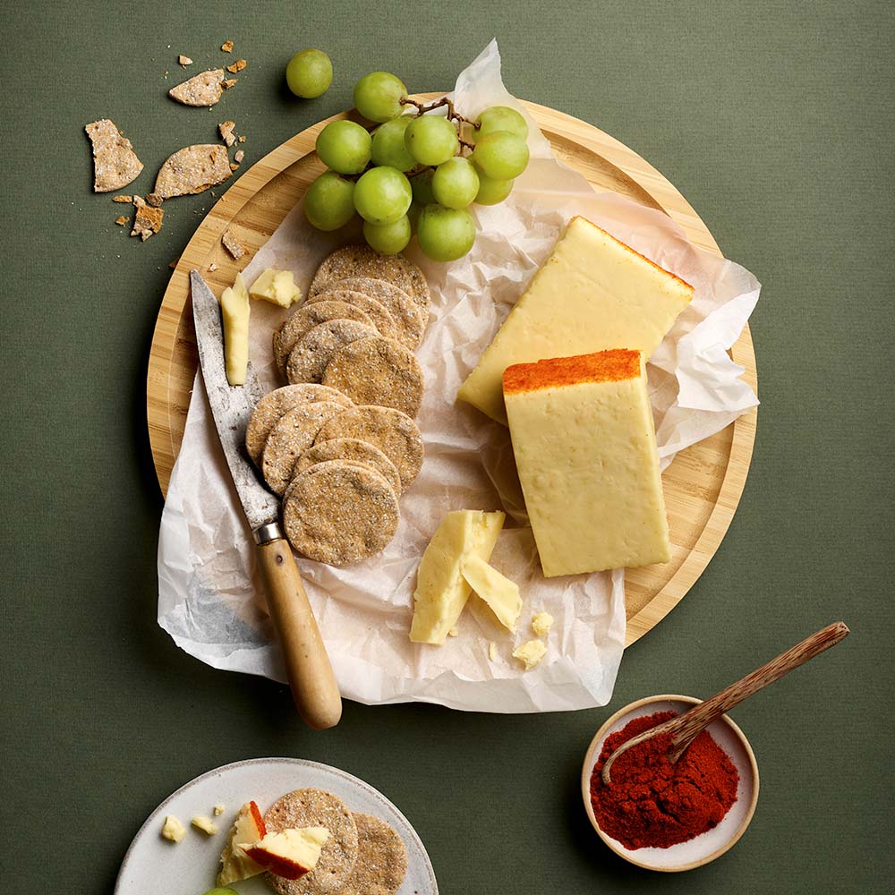 Applewood smoked cheddar cheese with crackers and grapes